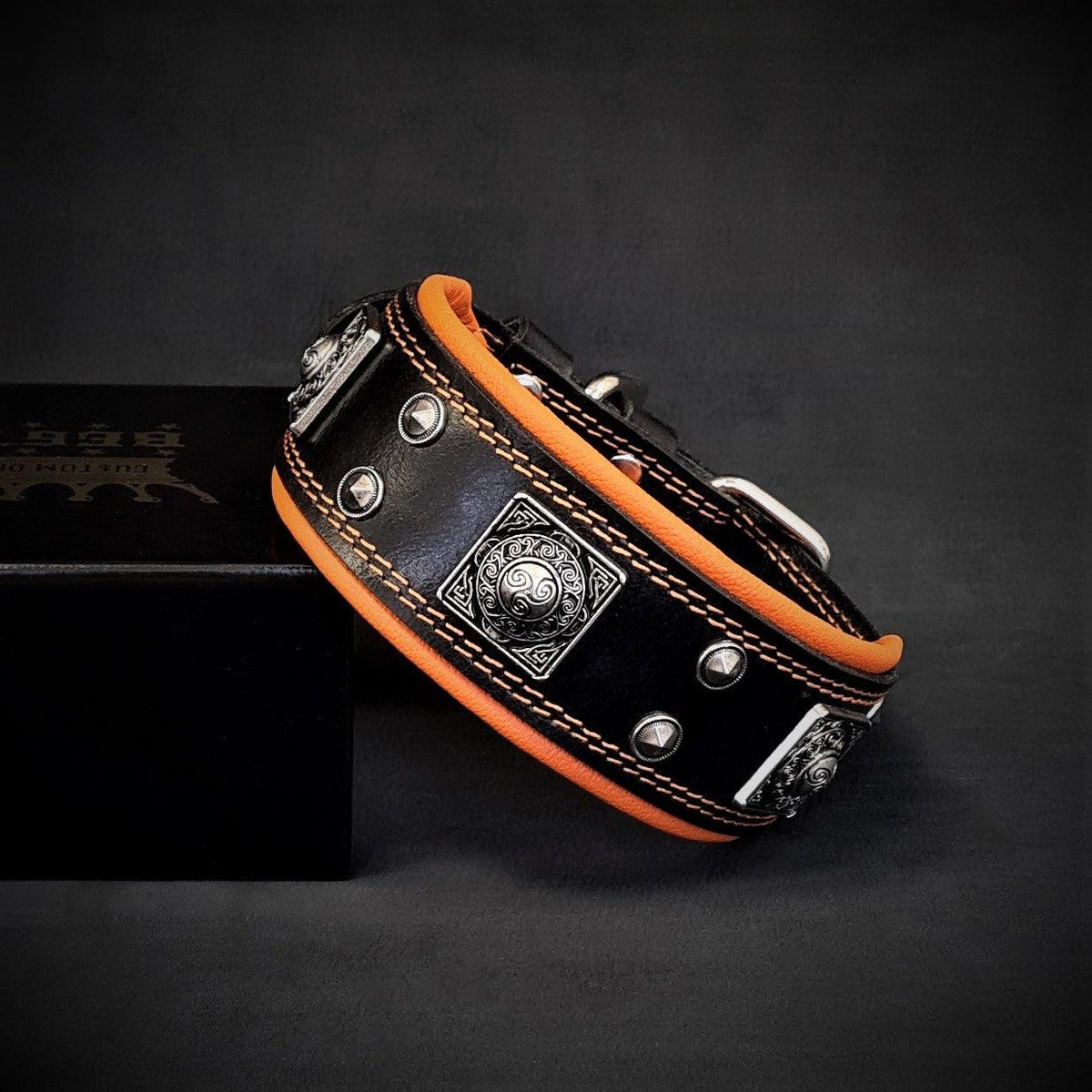 BESTIA Eros Lederhalsband in Schwarz mit orangefarbener Polsterung und silberfarbenen Ziernieten.