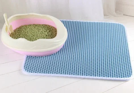 Hellblaue Katzenstreu-Matte mit Wabenstruktur unter einer offenen weiss-rosa Katzentoilette