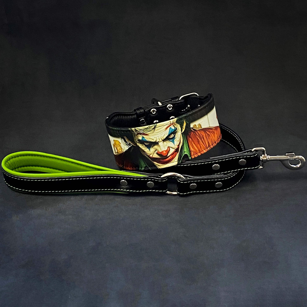 Schwarzes JK-Lederhalsband mit farbigem Joker-Motiv neben einer schwarzen Lederleine mit grüner Handschlaufenpolsterung und Metallkarabiner