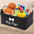 Dunkelgrauer Filzkorb mit Holzgriffen, gefüllt mit buntem Hundespielzeug und der Aufschrift «Dog Toys»