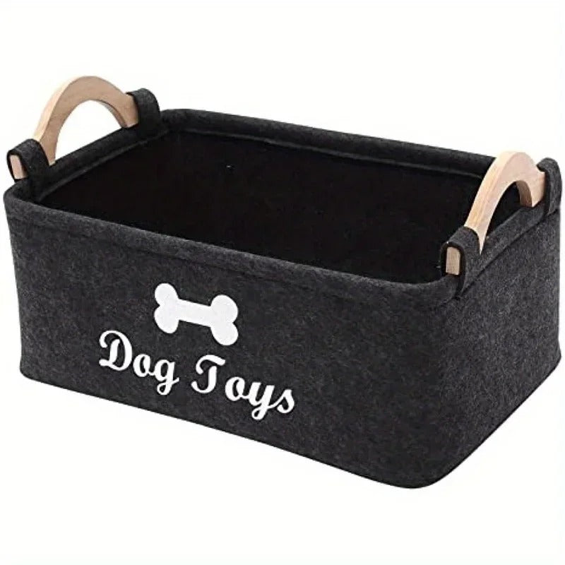 Leerer dunkelgrauer Filzkorb mit Holzgriffen, weissem Knochenmotiv und der Aufschrift «Dog Toys»