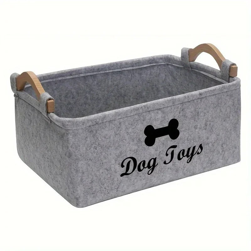 Leerer hellgrauer Filzkorb mit Holzgriffen, schwarzem Knochenmotiv und der Aufschrift «Dog Toys»