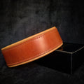 Braunes Style-Lederhalsband mit heller Polsterung und passenden Nähten auf dunklem Hintergrund