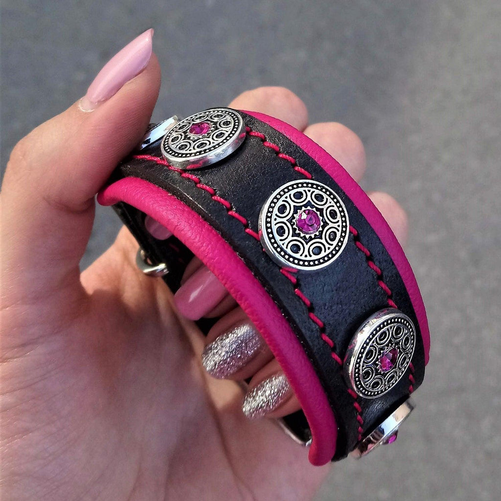 Nahaufnahme des BESTIA Bijou Lederhalsbands mit pinker Polsterung, pinken Nähten und silberfarbenen Zierelementen.