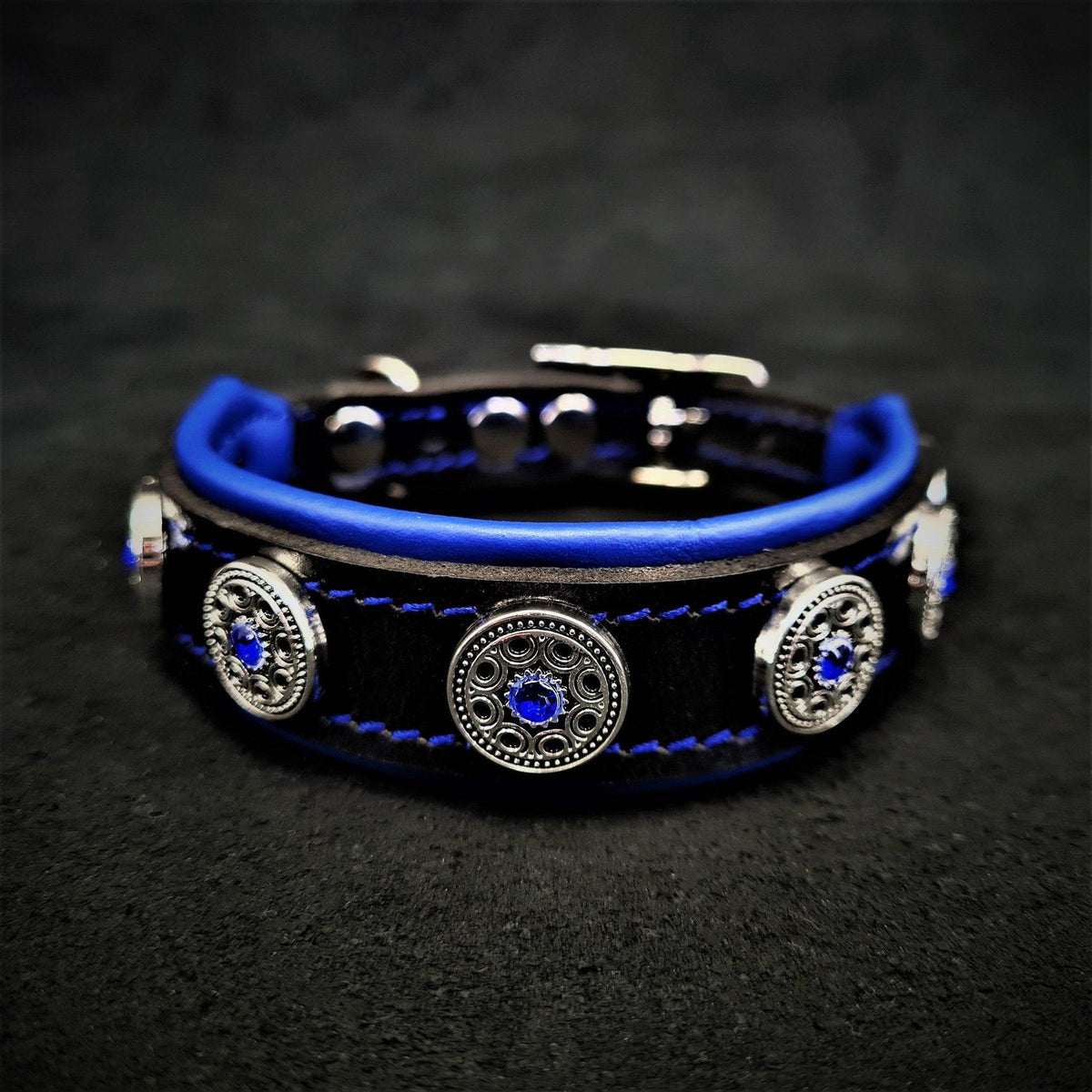 BESTIA Bijou Lederhalsband in Schwarz/Blau mit blauer Polsterung und silberfarbenen Zierelementen mit blauen Steinen.