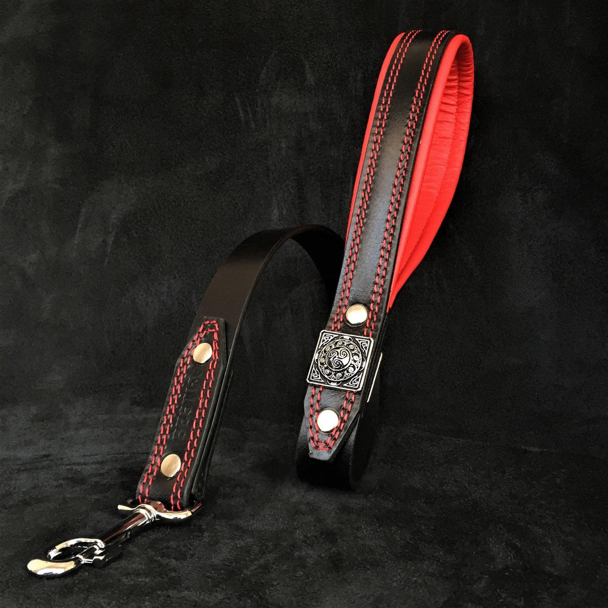 Passende BESTIA Eros Lederleine in Schwarz mit rot gepolstertem Griff, roten Nähten und silberfarbenem Karabiner.