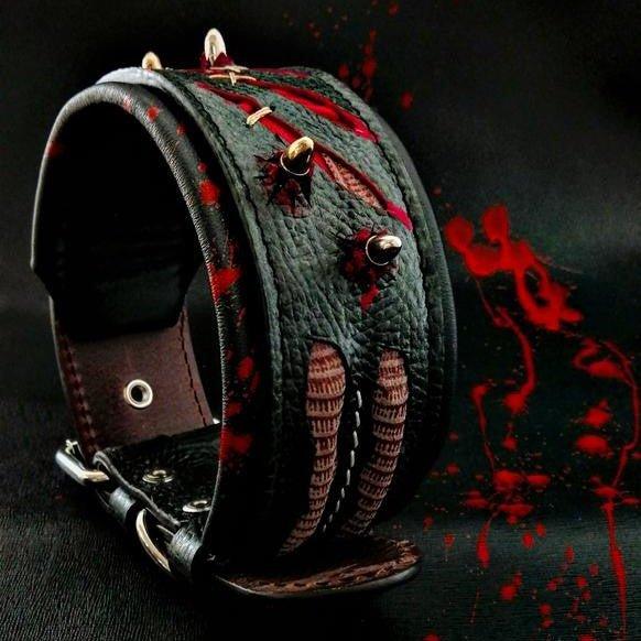 Dunkles Haunted-Lederhalsband mit roten Kratzspuren-Motiven, Ziernähten und metallfarbenen Spikes auf schwarzem Hintergrund