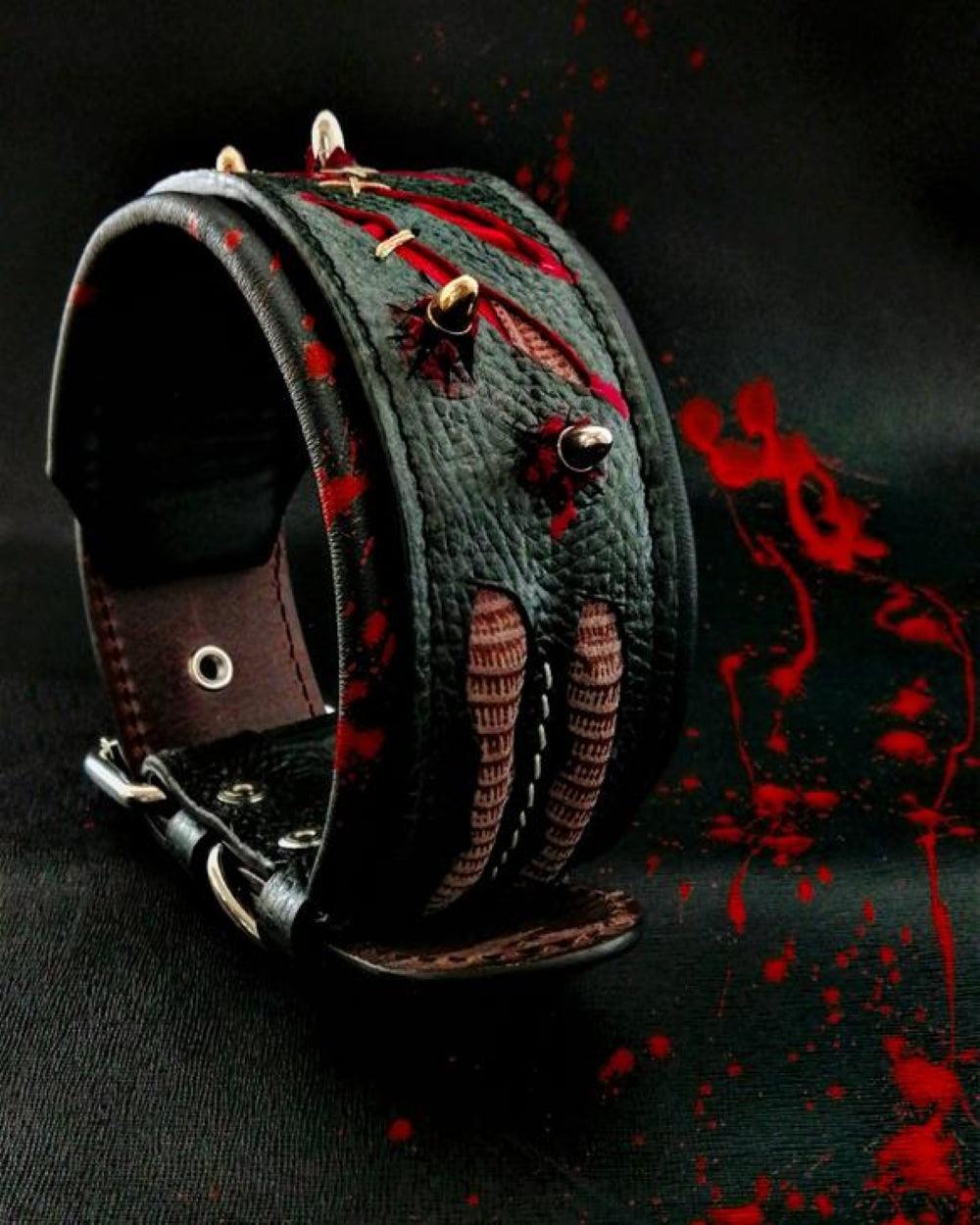 Dunkles Haunted-Lederhalsband mit roten Kratzspuren-Motiven, Ziernähten und metallfarbenen Spikes auf schwarzem Hintergrund