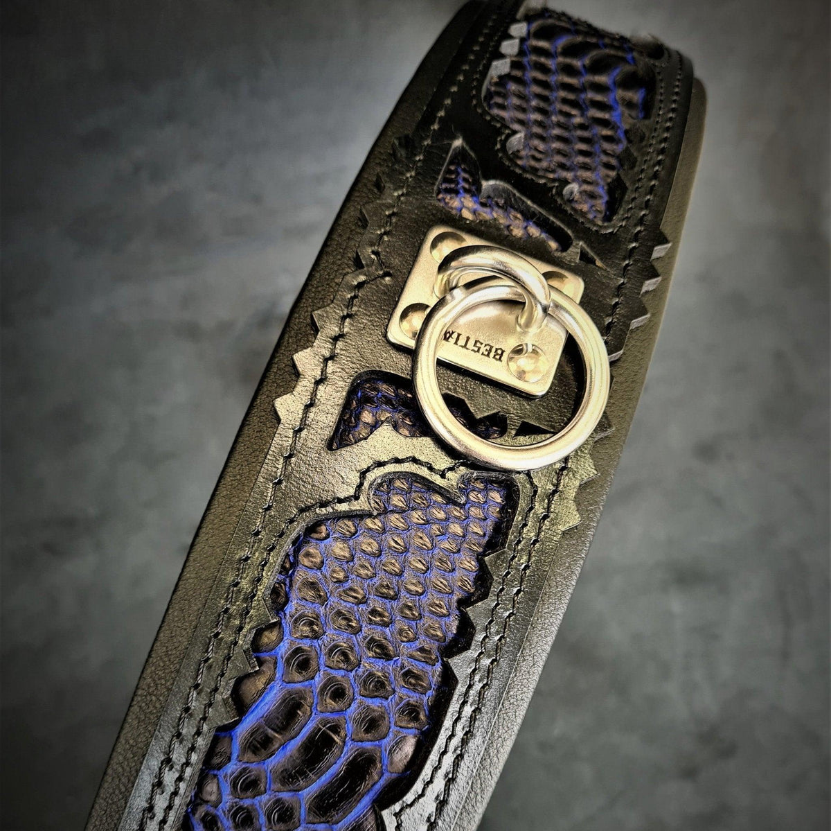 BESTIA Indigo Lederhalsband mit blau-schwarzem Schuppenmuster, Ziernähten und silberfarbenem Metallring.