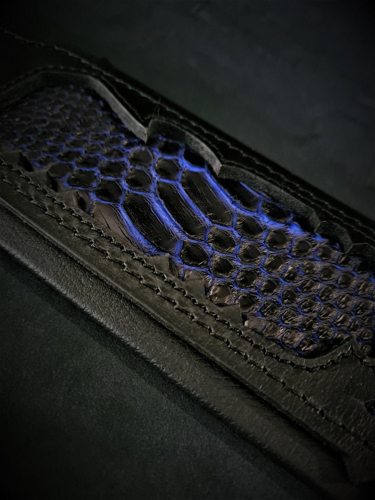 Detail des BESTIA Indigo Halsbands mit blau-schwarzem Schuppenmuster und Nähten im schwarzen Leder.