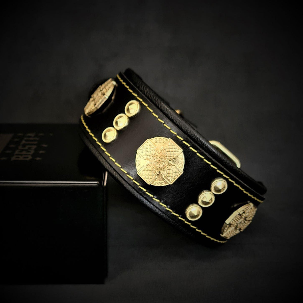 Schwarzes Maximus-Lederhalsband mit goldfarbenen Zierscheiben und Nieten, gelben Nähten und schwarzer Polsterung