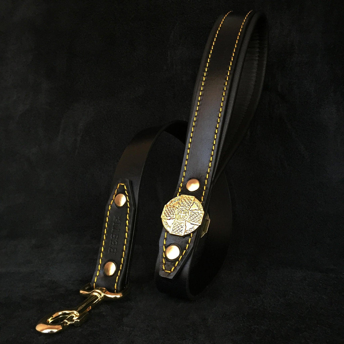 Schwarze Maximus-Lederleine mit goldfarbener Zierscheibe, Karabiner und gelben Nähten