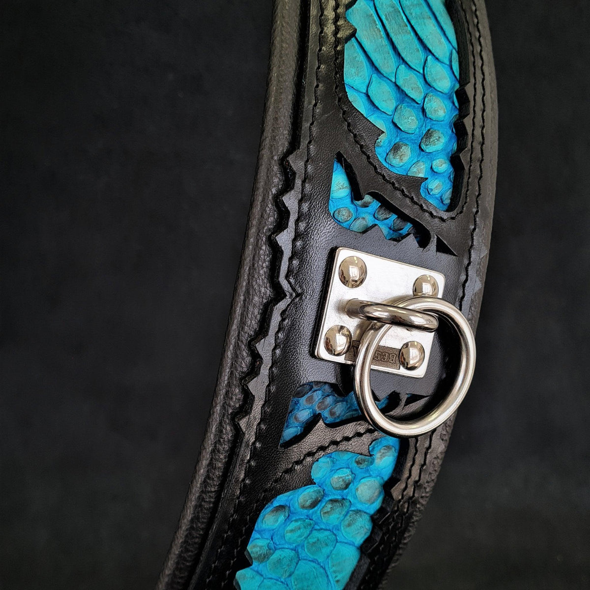 Detailansicht des BESTIA Morelia Python Lederhalsbands mit blauen Einsätzen im Pythonmuster und silberfarbenem Leinenring.