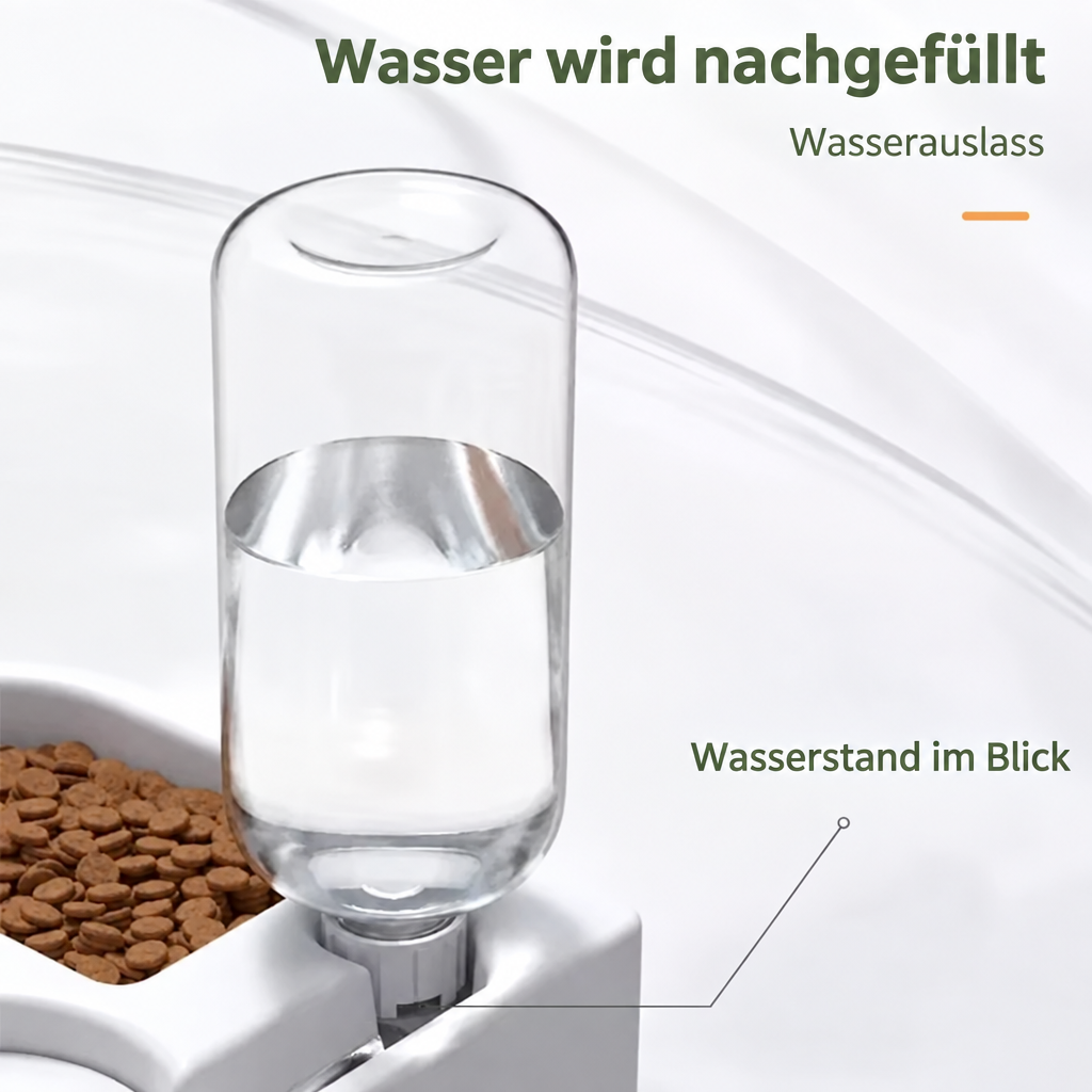 Nahaufnahme der transparenten Wasserflasche am Doppelnapf mit sichtbarem Füllstand und markiertem Wasserauslass